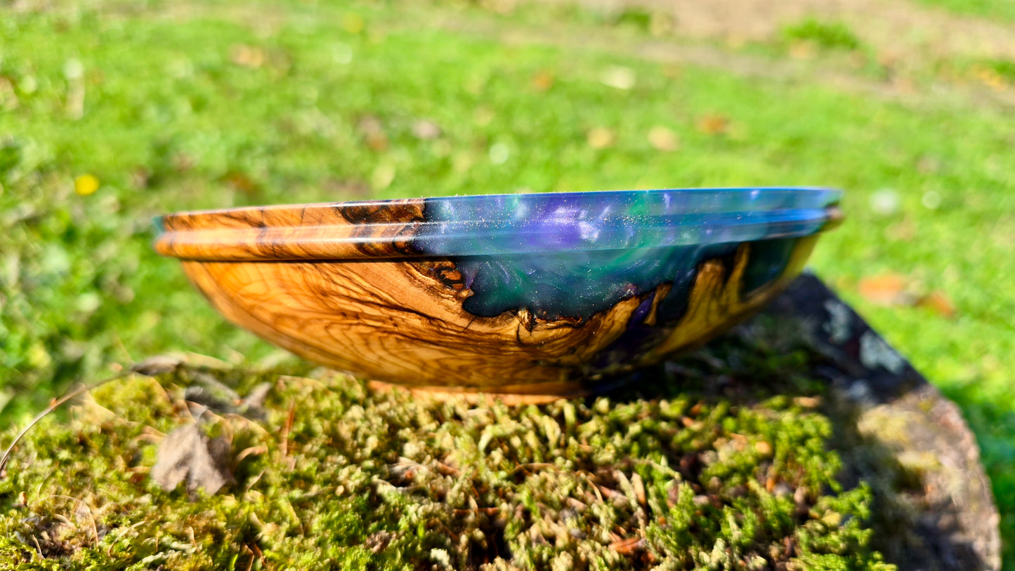 One-of-a-kind handmade epoxy and olive wood bowl in natural outdoor setting