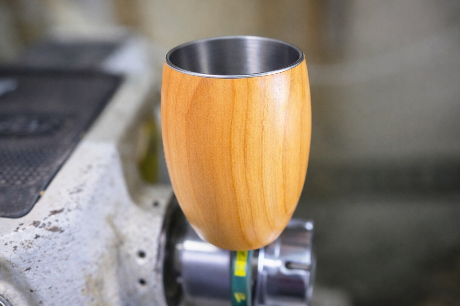 Cherry wood cup held in hand showing size and natural finish