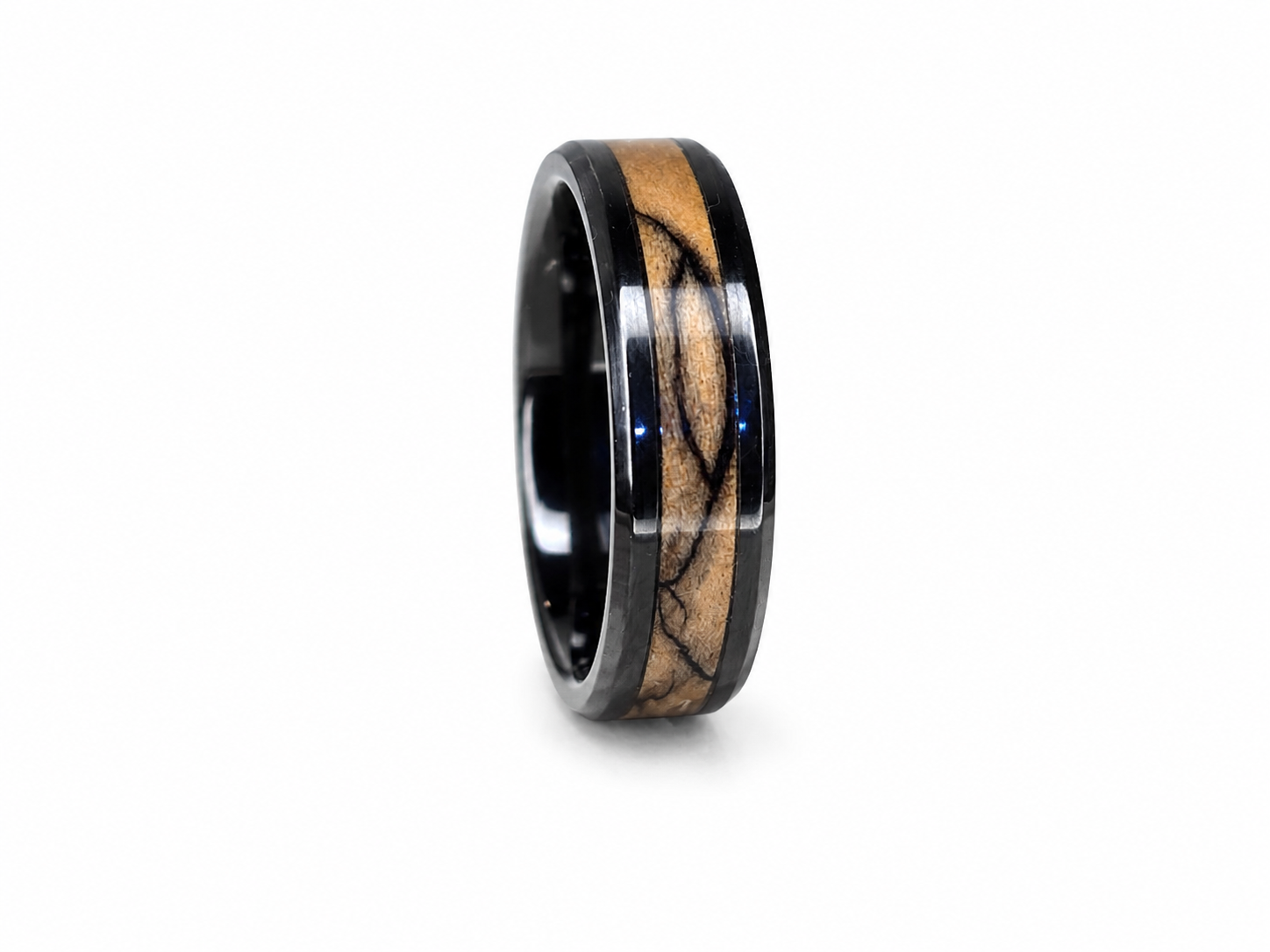 Close-up of handcrafted olive wood ring with blue pearl epoxy and ceramic inlay