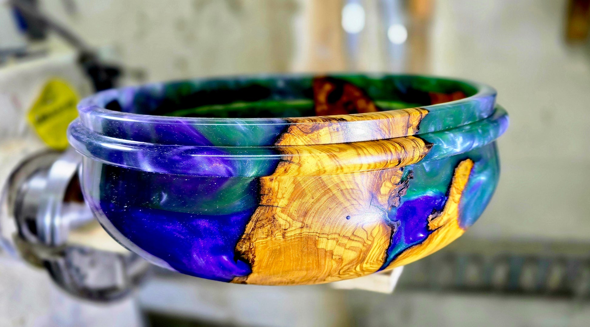 Close-up detail of olive wood grain and epoxy resin in handmade wooden bowl