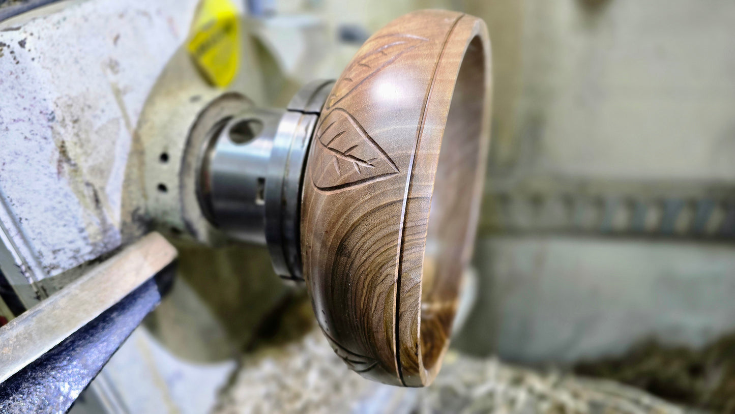 Artisan woodturning walnut bowl with carved leaf motif
