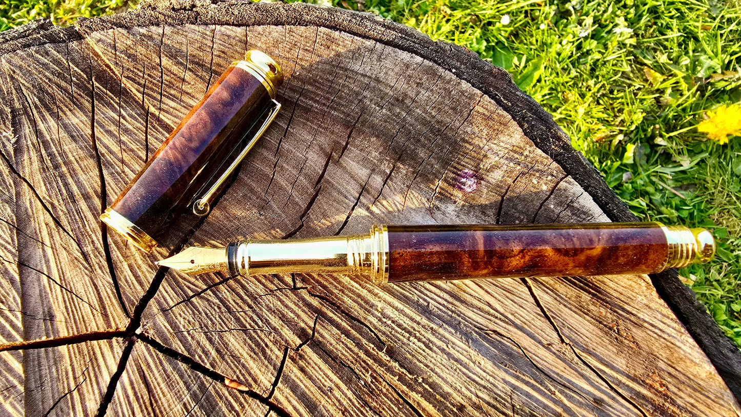 Handmade wooden fountain pen with rich walnut burl texture and gold details